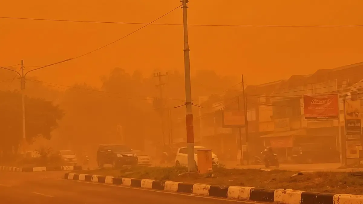 Langit berwarna jingga pekat menyelimuti jalan raya penduduk, Palangka Raya, Kalimantan Tengah, akibat kabut asap karhutla pada Rabu (14/10). Kondisi tersebut mengganggu jarak pandang pengendara yg berlalu lintas.